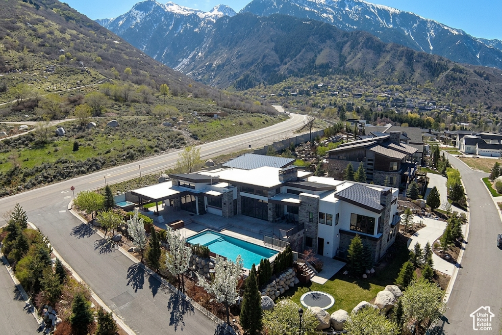 Aerial view of a modern Granite Oaks home with a pool below the snow-capped Wasatch Mountains