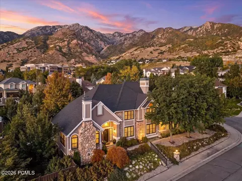 Stone-front home in Old Mill Estates at dusk below the Wasatch Mountains